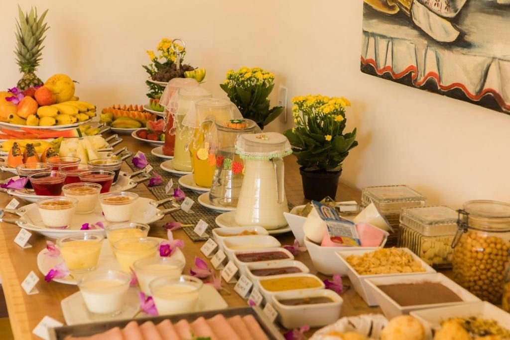 Mesa do café colonial com frutas, sucos e quitutes