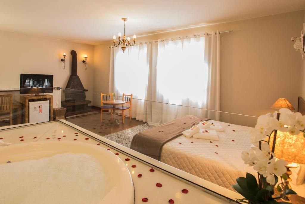 Suíte com hidromassagem, lareira e pétalas de rosas sobre a cama